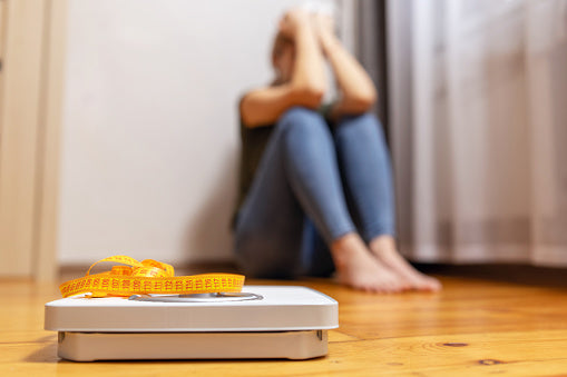 unhappy person on the floor sad because they are over their goal weight - they are considering taking microactive oligonol for weight loss and microactive oligonol for fat burning