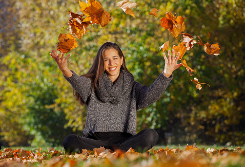 women playing in the leaves - she is happy to do a fall detox, liver detox equinox with glutathione